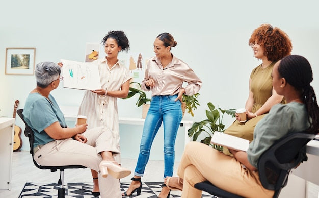 A photo of a group of women engaged in a workshop where two women are showing them how to do a side hustle